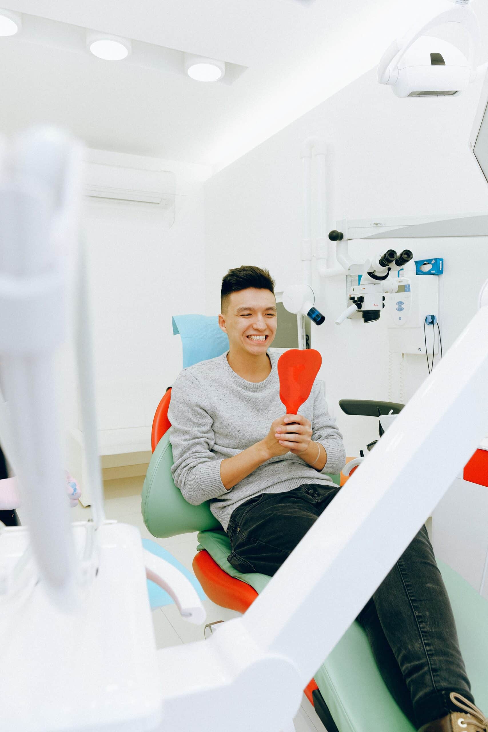 man smiling in a mirror at the dentist